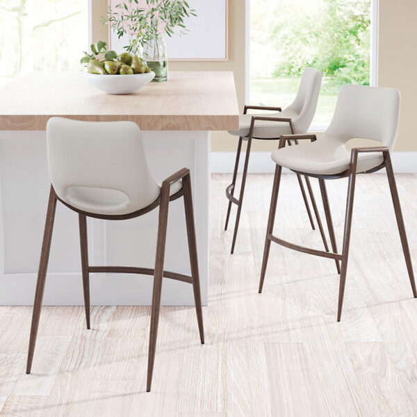 three staged beige faux leather barstool with brown painted steel legs. oval opening in lower back of barstool seat.