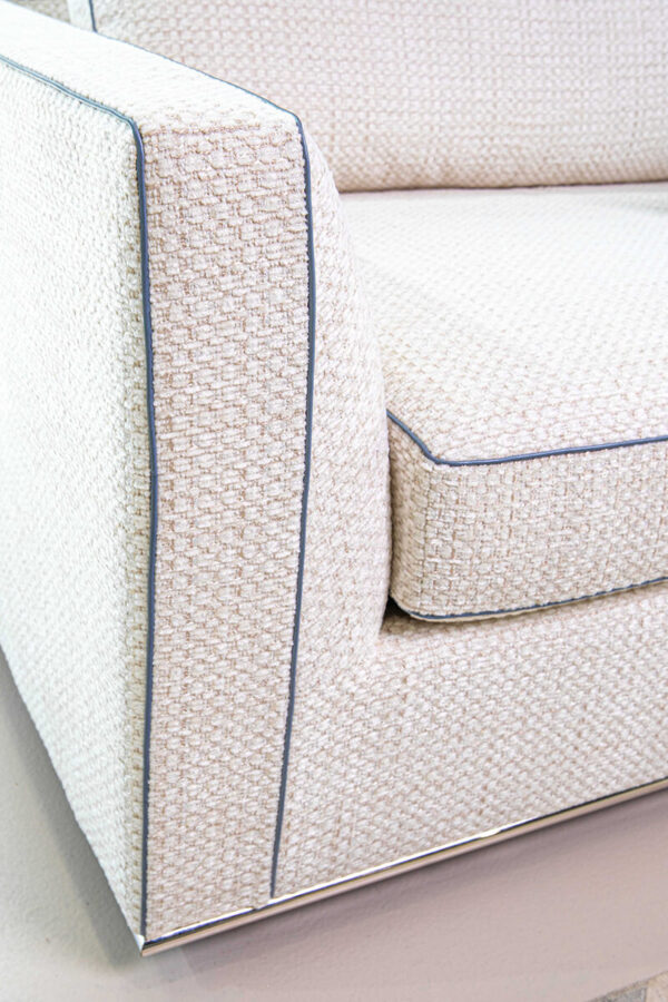 a closeup image of Siena in a contemporary white fabric with blue welt and silver leg on a sofa by American Leather