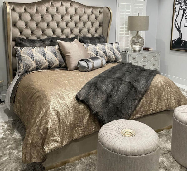 a traditional bed with the tufted headboard in a shiny taupe fabric with a gold finish trim