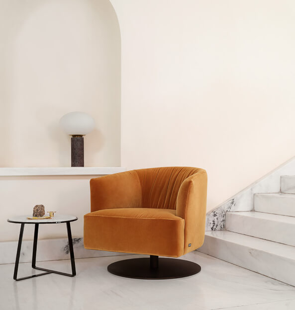 orange snug looking circular swivel arm chair on round black base in a sleek hallway