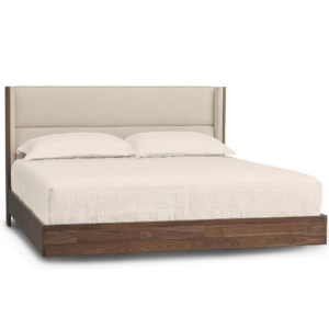 Modern floating walnut platform bed with upholstered headboard in a cream fabric.